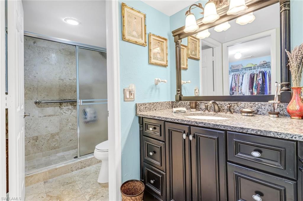 3041 Sandpiper Bay Circle, Unit H201 Naples, FL 34112 - Photo 16 of 25 Bathroom featuring a walk in closet, a stall shower, vanity, and light tile patterned floors