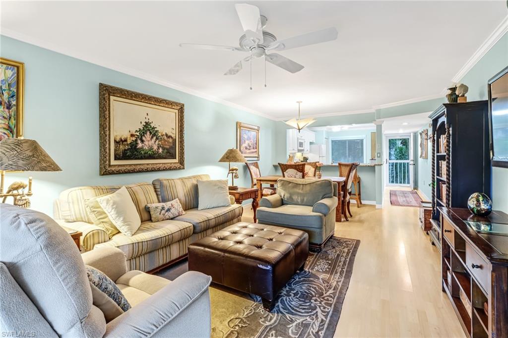 3041 Sandpiper Bay Circle, Unit H201 Naples, FL 34112 - Photo 9 of 25 Living room featuring crown molding, light wood-type flooring, ceiling fan, and ornate columns