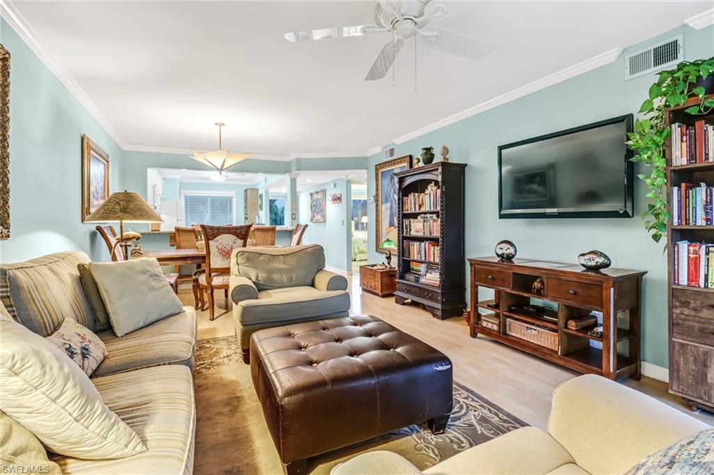 3041 Sandpiper Bay Circle, Unit H201 Naples, FL 34112 - Photo 10 of 25 Living room with ornamental molding, wood finished floors, and a ceiling fan