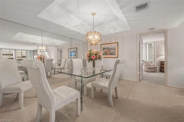 a view of a dining room with furniture and chandelier