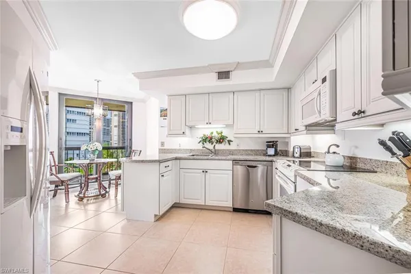 a kitchen with granite countertop sink window and white appliances