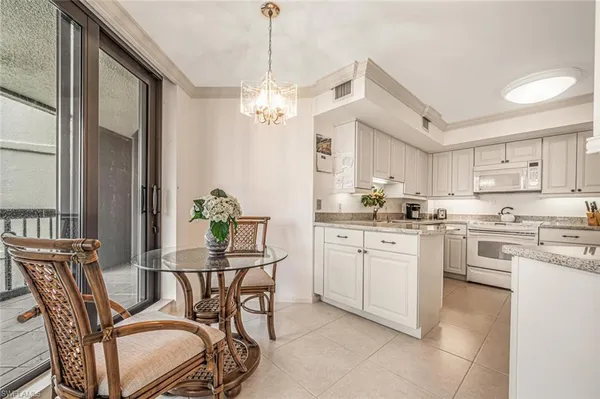 a kitchen with stainless steel appliances kitchen island granite countertop a dining table chairs and granite counter tops