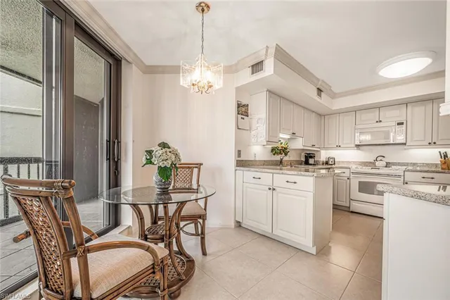 a kitchen with stainless steel appliances kitchen island granite countertop a dining table chairs and granite counter tops