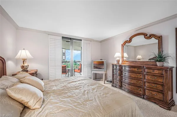 a bedroom with a bed and a dresser with mirror