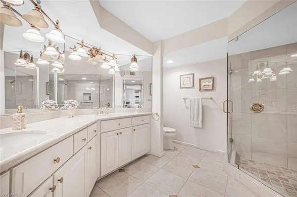 a spacious bathroom with a double vanity sink mirror and a shower