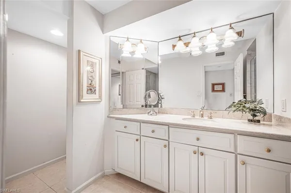 a bathroom with double sink and a mirror
