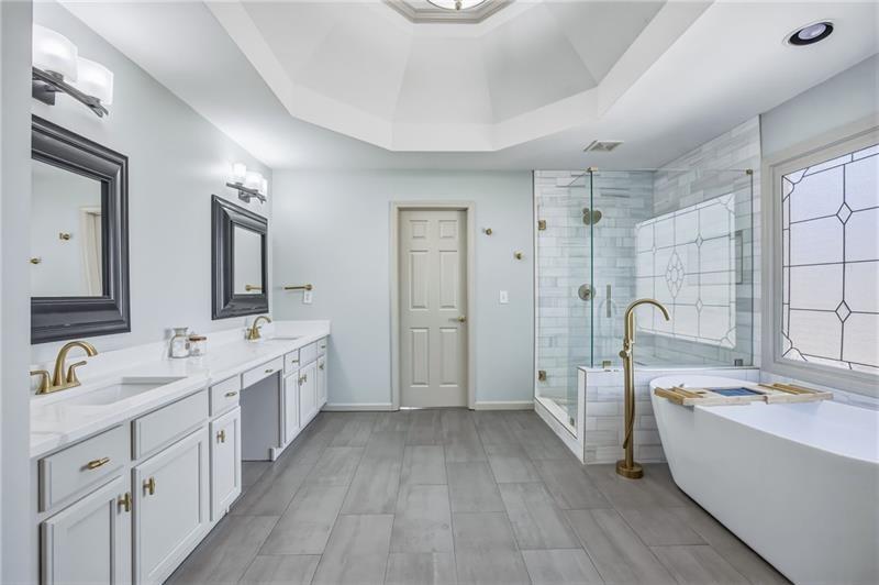 4862 Manatee Court Northwest Powder Springs, GA 30127 - Photo 27 of 46 a large white bathroom with a double vanity sink a mirror and a bathtub