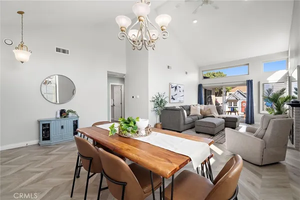 a living room with furniture chandelier and a mirror