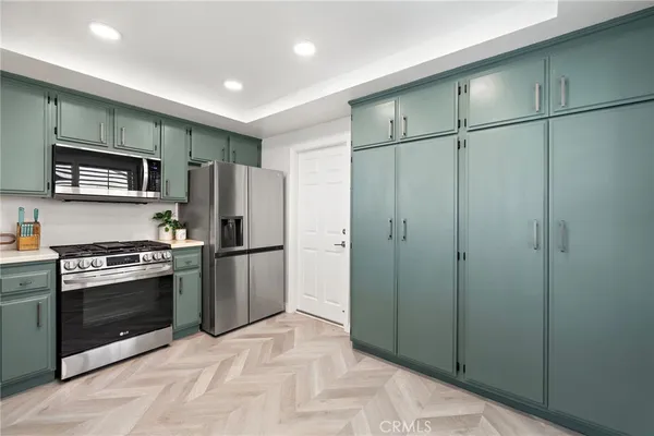 a kitchen with stainless steel appliances granite countertop a refrigerator and a stove top oven