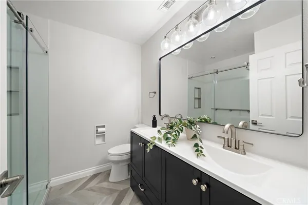 a bathroom with a double vanity sink toilet and a mirror