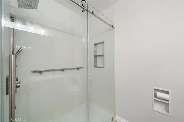 a bathroom with a shower and a glass door