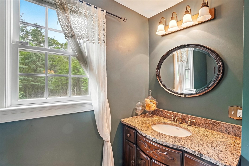 56 Grafton Road Upton, MA 01568 - Photo 22 of 34 a bathroom with a granite countertop bathtub a sink and a mirror