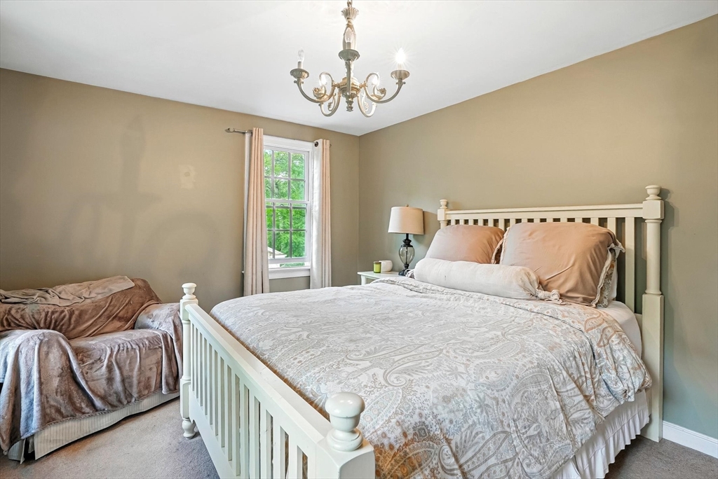 56 Grafton Road Upton, MA 01568 - Photo 24 of 34 a bedroom with a bed and a chandelier