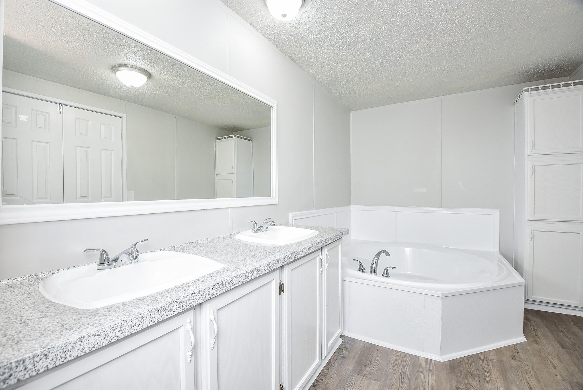 12842 Roy Harris Loop Conroe, TX 77306 - Photo 31 of 36 a bathroom with a granite countertop sink and a mirror