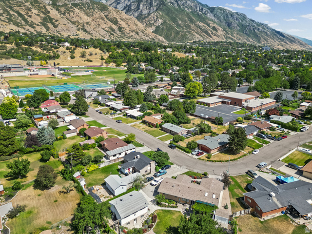 542 East 3400th Street North Provo, UT 84604 - Photo 34 of 39 Aerial perspective showcasing a residential area with diverse home styles, mature trees, and mountainous terrain