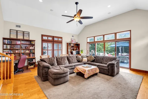 a living room with furniture and a large window with bookshelf