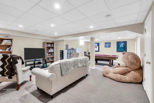 a living room with furniture a ceiling fan and a flat screen tv