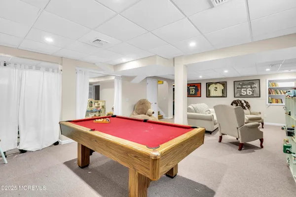 a room with pool table and windows