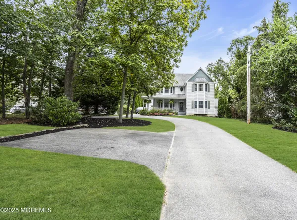 a front view of a house with a yard and trees
