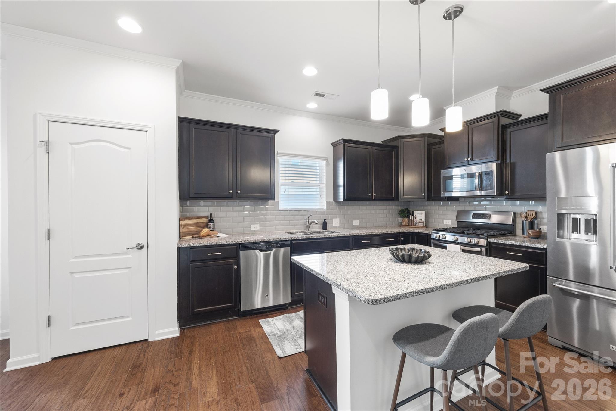 1214 Brookcrest Lane Fort Mill, SC 29708 - Photo 12 of 41 a kitchen with stainless steel appliances granite countertop a sink a stove a refrigerator and island with wooden floor