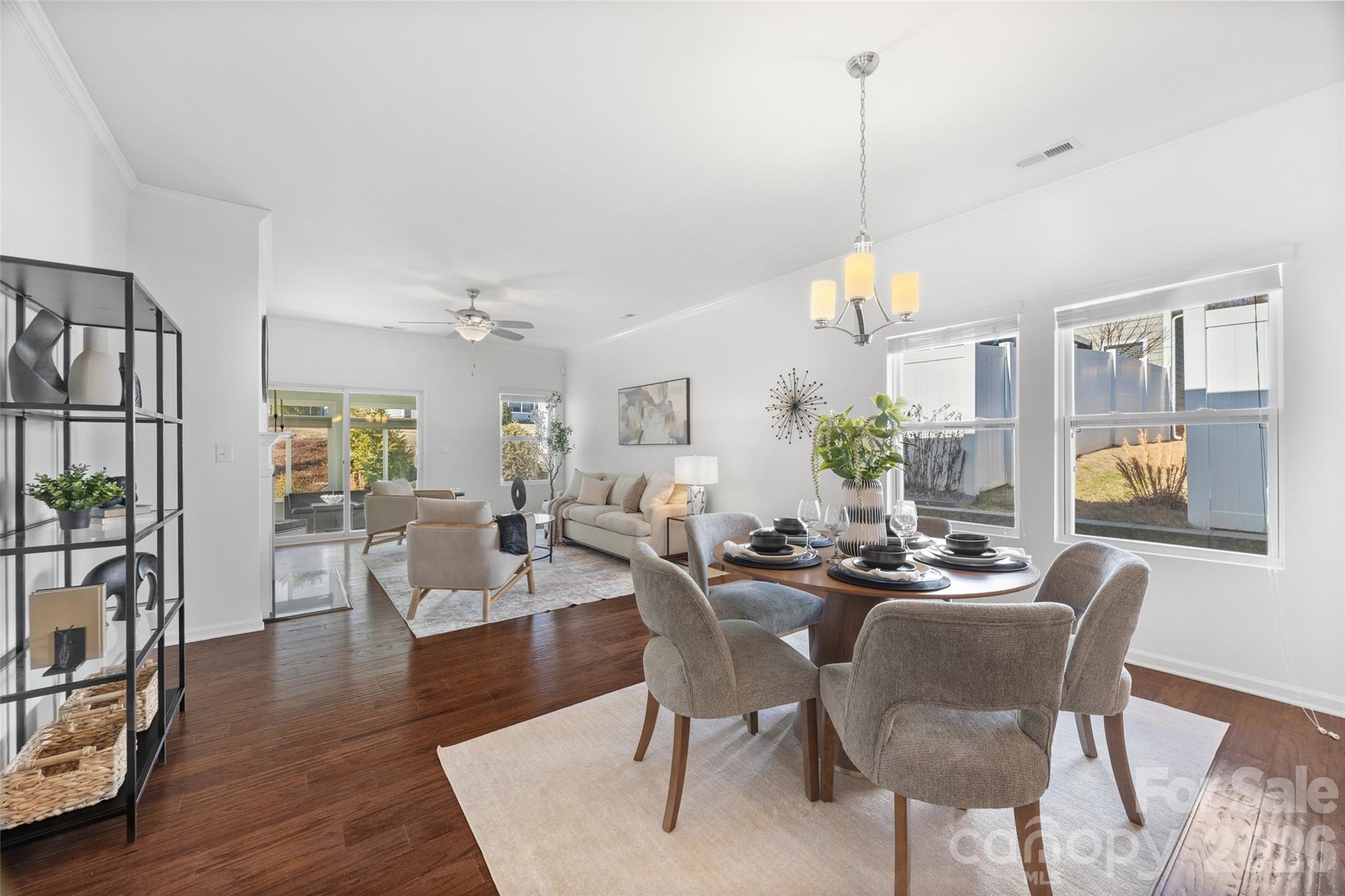 1214 Brookcrest Lane Fort Mill, SC 29708 - Photo 16 of 41 a view of a dining room and livingroom with furniture wooden floor a rug a potted plant and a chandelier