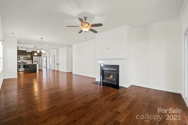 a view of empty room with wooden floor and fireplace