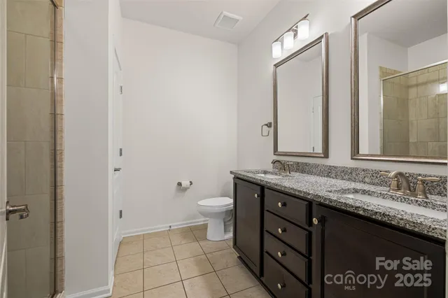 a bathroom with a granite countertop sink a toilet and a mirror