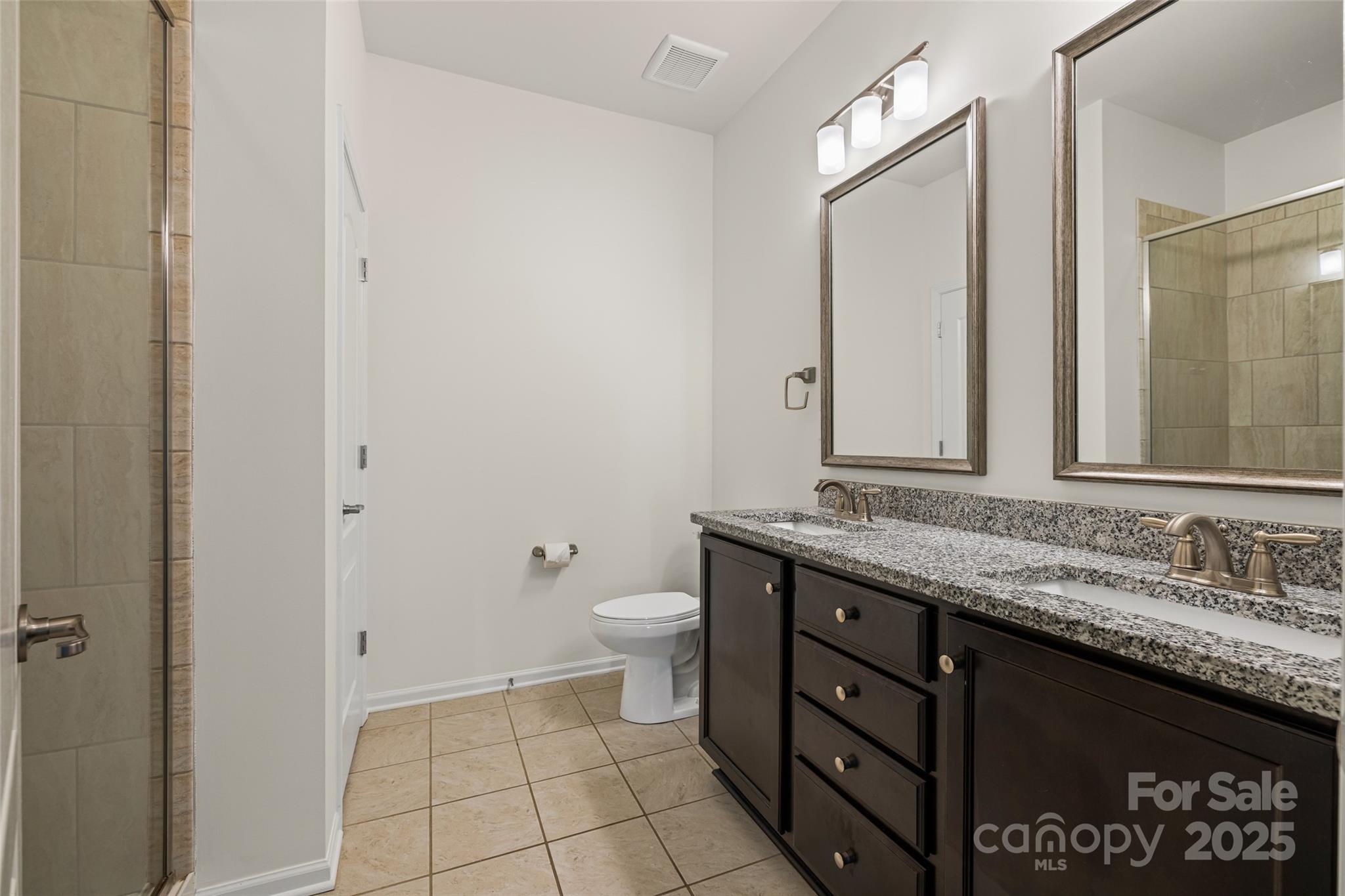 1214 Brookcrest Lane Fort Mill, SC 29708 - Photo 24 of 41 a bathroom with a granite countertop sink a toilet and a mirror