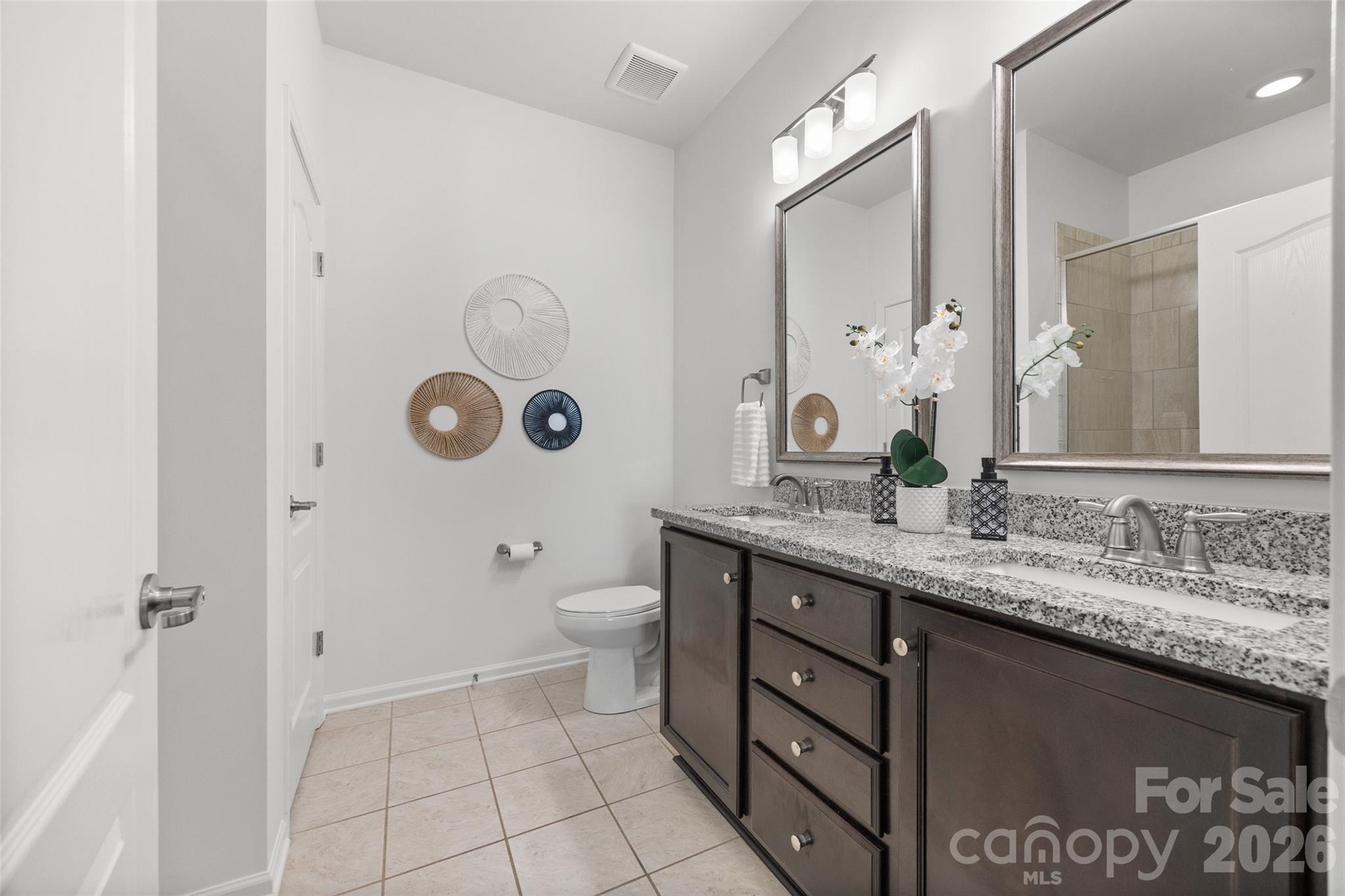 1214 Brookcrest Lane Fort Mill, SC 29708 - Photo 26 of 41 a bathroom with a granite countertop sink a toilet and a mirror