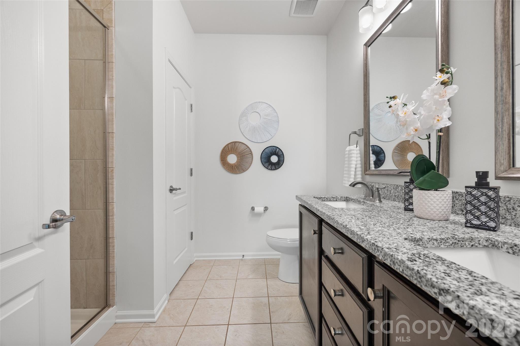 1214 Brookcrest Lane Fort Mill, SC 29708 - Photo 27 of 41 a bathroom with a granite countertop sink a toilet and shower curtain