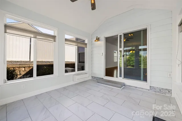 a view of an empty room with a fireplace and windows
