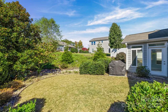 a view of a house with potted plants and a large tree