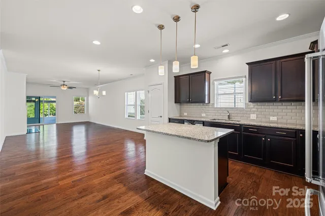 a kitchen with stainless steel appliances granite countertop a sink stove and wooden floor