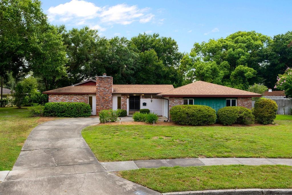 541 London Road Winter Park, FL 32792 - Photo 1 of 1 a view of a white house with a yard and table and chairs under an umbrella