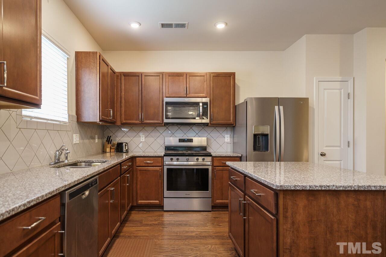 4100 Catfish Wy. Durham, NC 27703 - Photo 11 of 29 a kitchen with stainless steel appliances granite countertop a stove a sink dishwasher a refrigerator and a microwave