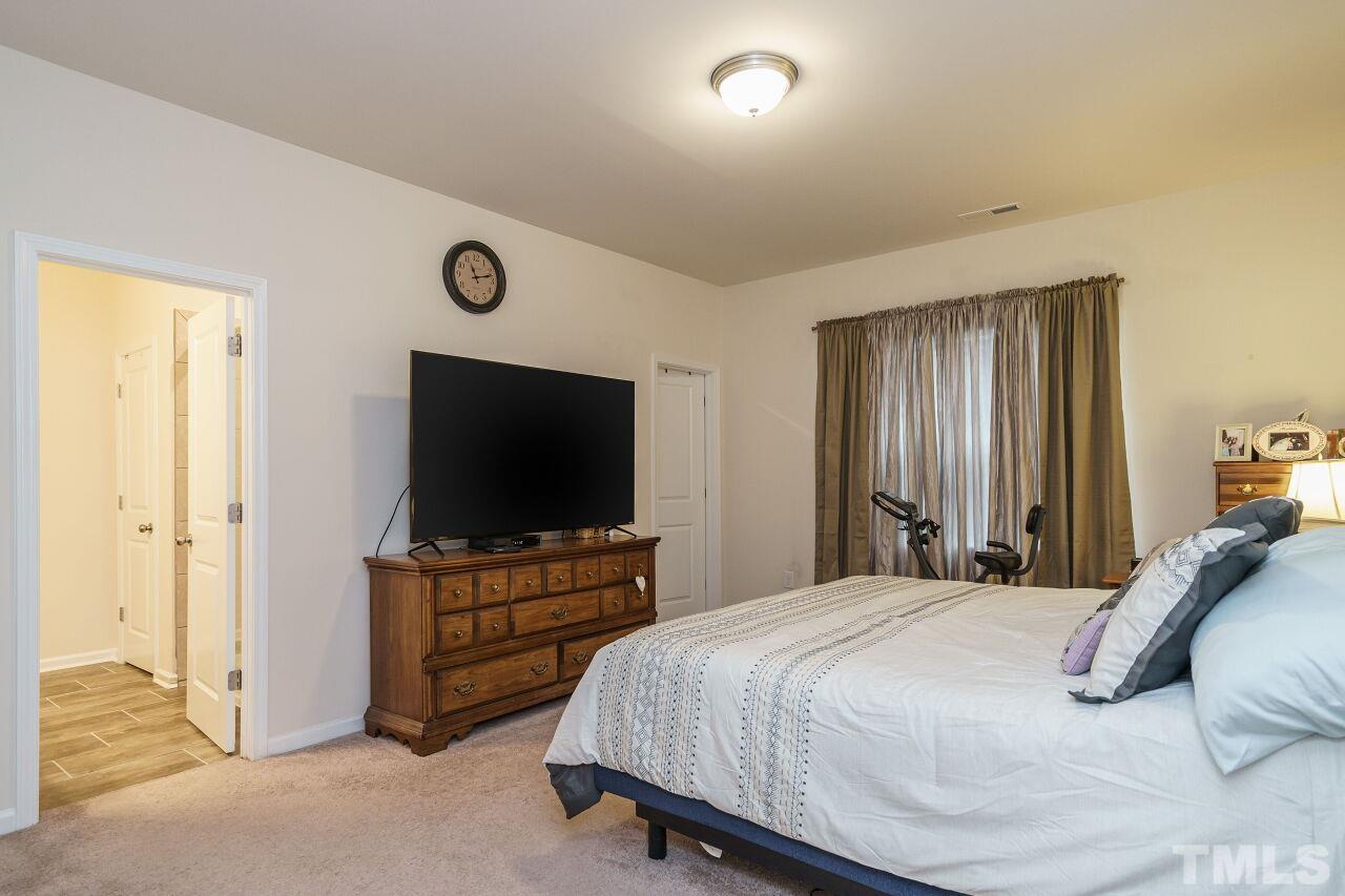 4100 Catfish Wy. Durham, NC 27703 - Photo 17 of 29 a bedroom with a bed and a flat screen tv