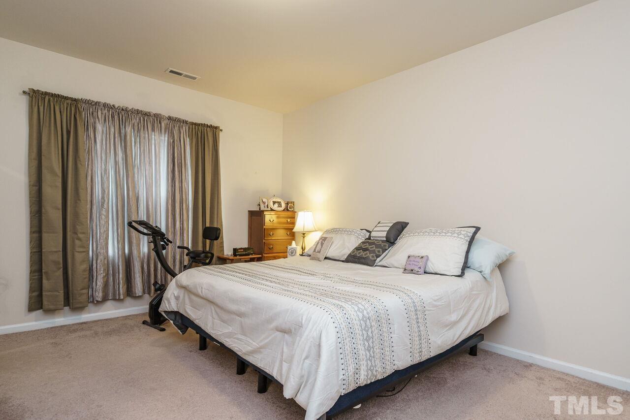 4100 Catfish Wy. Durham, NC 27703 - Photo 18 of 29 a bedroom with a bed lamp and a window