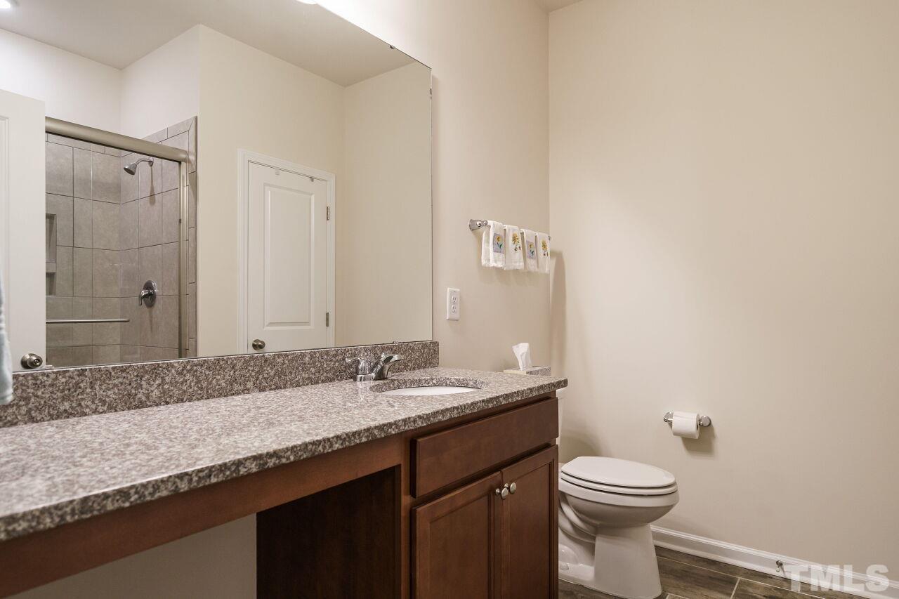4100 Catfish Wy. Durham, NC 27703 - Photo 19 of 29 a bathroom with a granite countertop sink a toilet and a mirror