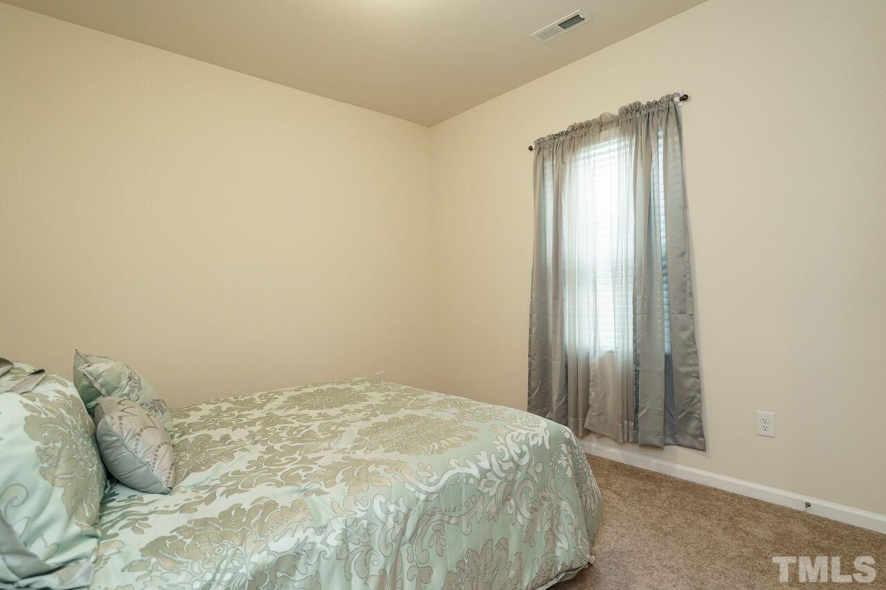 4100 Catfish Wy. Durham, NC 27703 - Photo 21 of 29 a bedroom with a bed and a mirror