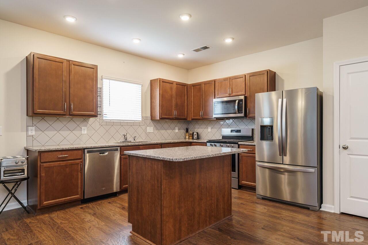 4100 Catfish Wy. Durham, NC 27703 - Photo 8 of 29 a kitchen with stainless steel appliances granite countertop a refrigerator stove microwave and sink
