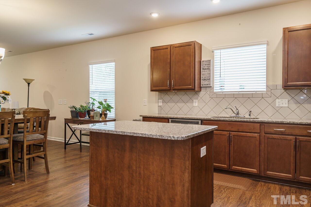 4100 Catfish Wy. Durham, NC 27703 - Photo 10 of 29 a kitchen with stainless steel appliances granite countertop wooden cabinets a sink a stove a dining table and chairs