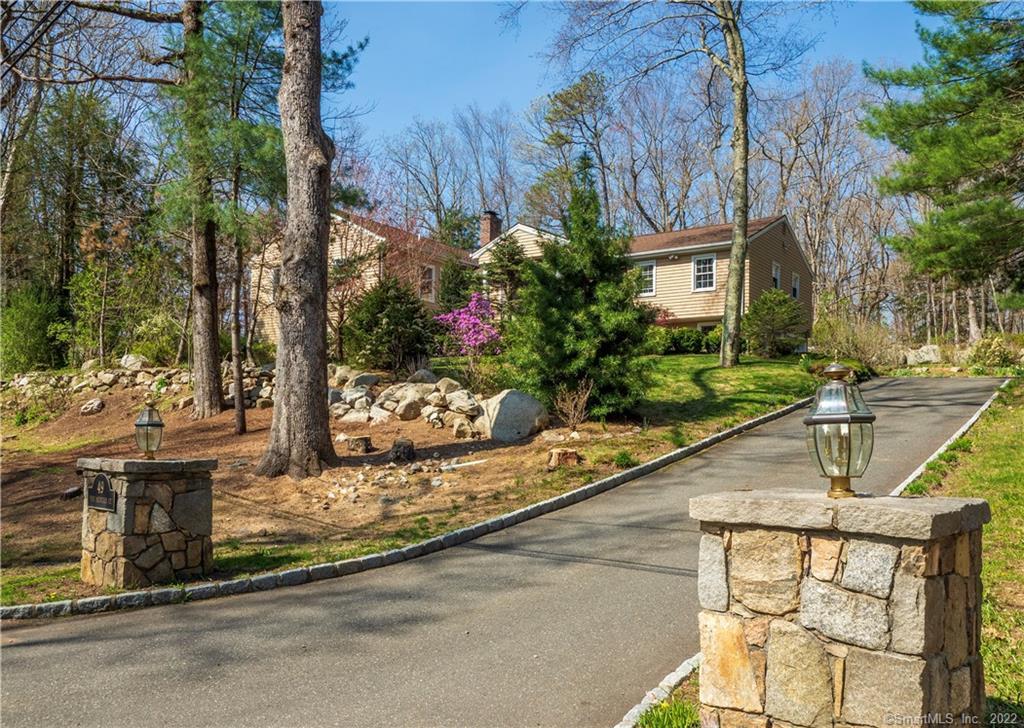 Lighted stone pillars and belgium block lined drive gracefully lead to this unique contemporary home.