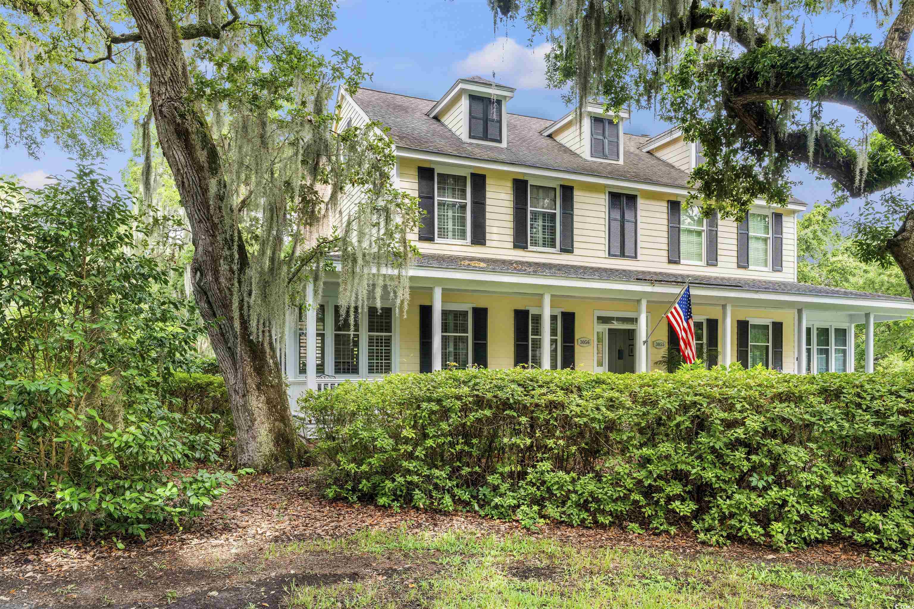 View of front of home featuring a shingled roof and covered porch