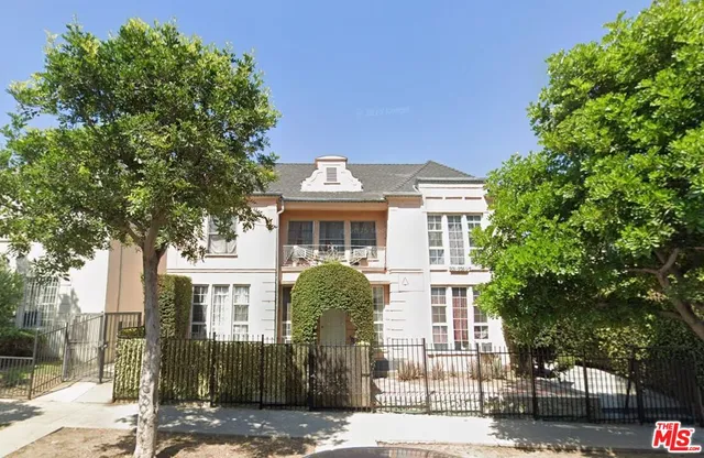 a front view of a house with a tree