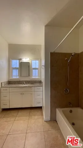 a bathroom with a granite countertop sink a toilet and bathtub