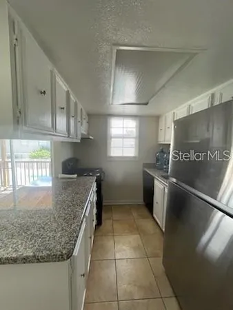 a kitchen with granite countertop a sink a stove and a refrigerator