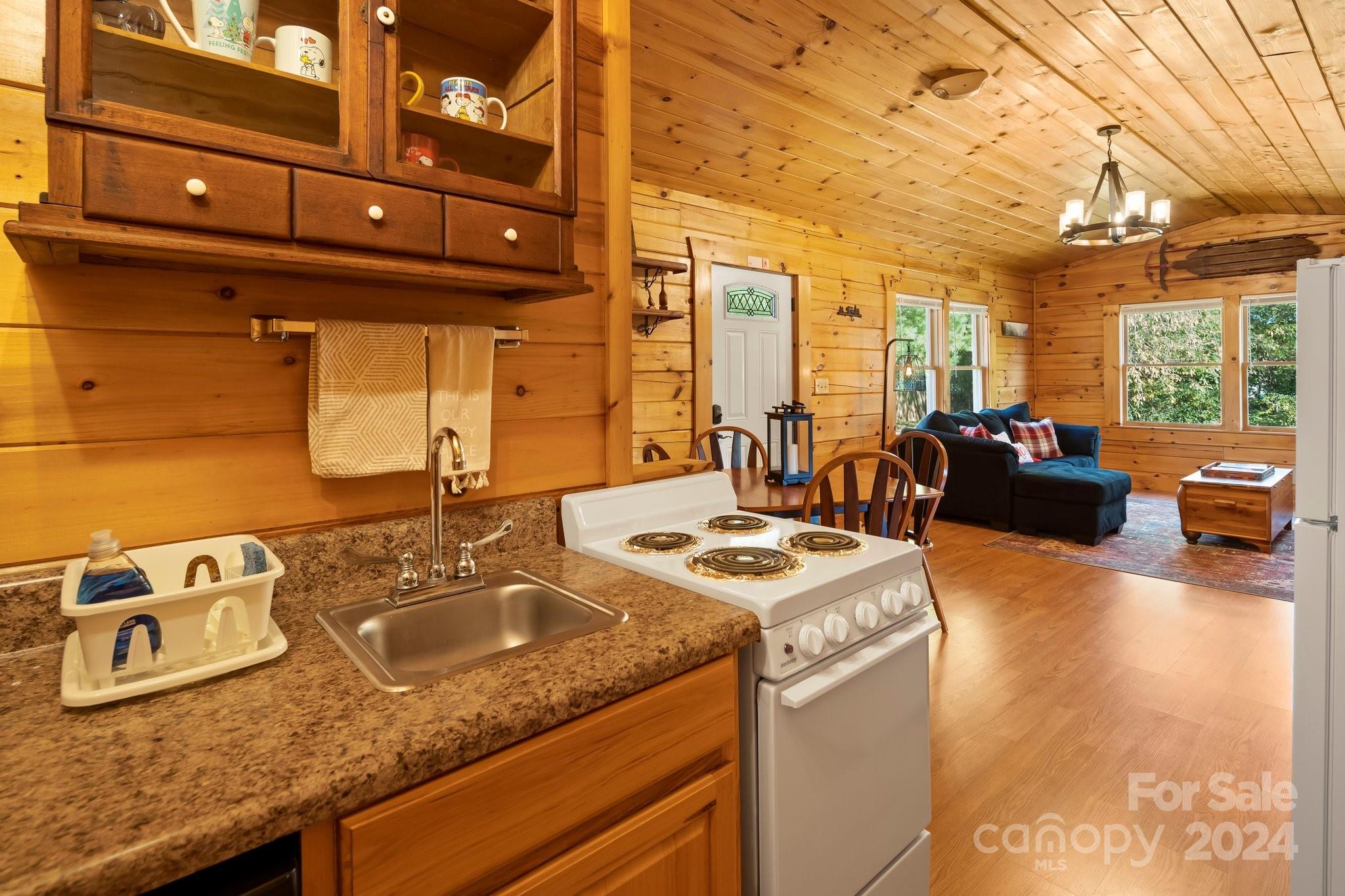 64 Bennett Road Candler, NC 28715 - Photo 12 of 24 a view of a kitchen with granite countertop a sink a stove and wooden cabinets