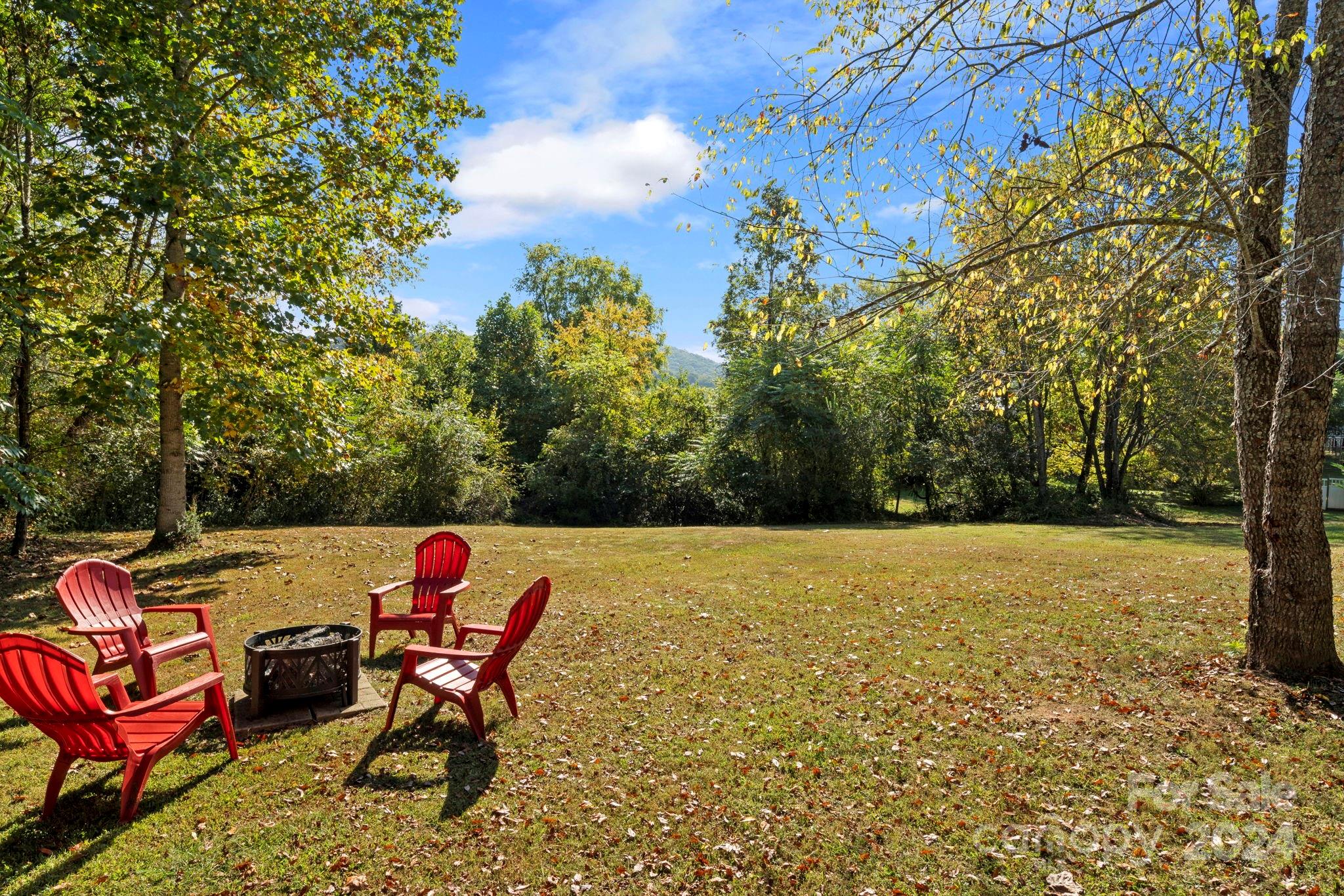 64 Bennett Road Candler, NC 28715 - Photo 21 of 24 a backyard of a house with table and chairs