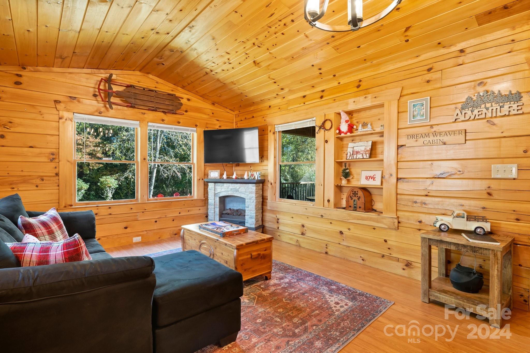 64 Bennett Road Candler, NC 28715 - Photo 5 of 24 a living room with furniture a fireplace and a flat screen tv