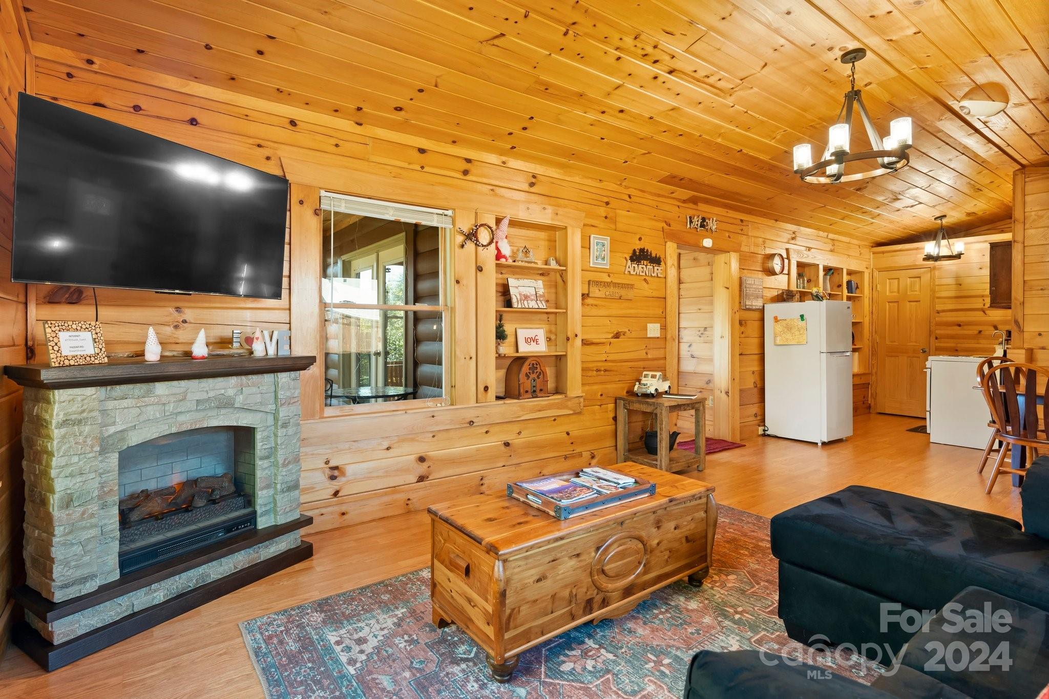 64 Bennett Road Candler, NC 28715 - Photo 7 of 24 a living room with furniture a flat screen tv and a fireplace